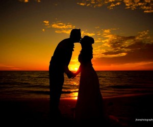 bride and groom kiss at sunset